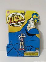 Full view of the sealed packaging showing the American Maid figure and card backing with The Tick branding.