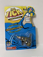 Full view of the toy in original packaging showing front with The Tick branding and toy inside a clear blister pack