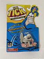 Front view of sealed 1995 The Tick Wing Flutterin Arthur Wacky Windups action toy in original packaging with bright yellow and blue theme.