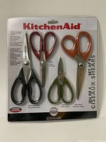 Front view of KitchenAid Shears set in package showing four different colored scissors and blades, labeled with types and uses.