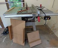 Front view of table saw on wheeled stand showing table top, Align-A-Rip fence and accessories laid out
