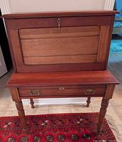 Desk closed, front view showing panelled drop-front and turned legs