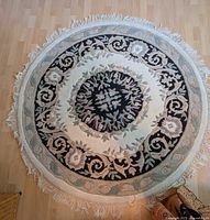 Overhead view of circular oriental carpet showing full pattern and fringe.