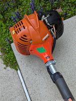 Close-up of orange Echo easy start engine housing with ECHO branding and black components showing vented air cover and starter handle