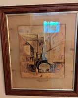 Framed antique watercolour painting depicting a historic street scene with the Old Town Gate in St Peter Port, Guernsey, dated 1831. The wooden frame and glass are visible.