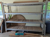 Front view of complete metal shelving unit with four wooden shelves and caster wheels