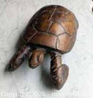 Top and side view of the large wooden turtle sculpture showing the carved shell and flippers.