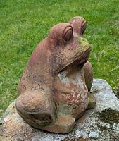 Side view of the Mexican terracotta frog planter showing weathered terracotta surface with moss and white patches.