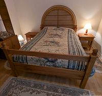 Full view of oak bed frame with headboard, bedding and cover