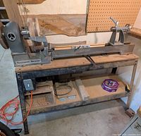 Full view of Rockwell Beaver lathe on metal stand showing cast iron bed, motor and pulley setup
