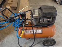 Full view of compressor with attached blue hose and tire inflator