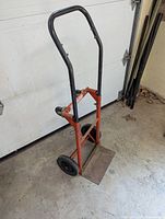 Front view of heavy duty two wheel dolly with black fixed wheels and red frame.