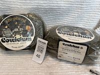 Two bags of Cowichan pure virgin wool showing front labels and packaging.