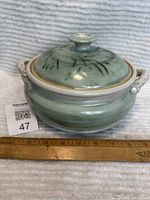 Front view of the berry bowl with lid and side handles, green glazed finish, approximately 6" x 9" in size.