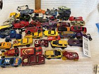 Overview of 50 assorted Hot Wheels cars from various years showing different colors and models including vintage types and modern styles.