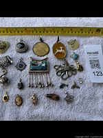 Comprehensive view of lot pendants and scarf ties with ruler showing size scale, approximately 7 to 12 cm lengths on some pieces.