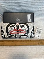 Full wallet in front of ruler for size reference with original box behind.