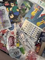 Photo showing a large batch of various McDonalds vintage promotional items in original packaging including rulers, flossers, toothbrushes, toy cars and coupon.