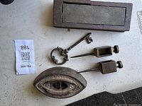 Lot showing wooden sharpening block, large skeleton key, sharpening iron block, and trammel points from above