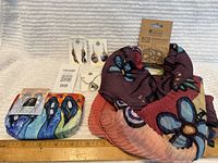 Photo showing entire lot laid out: two pairs of earrings on cards, a necklace on card, colorful indigenous cosmetic bag, and eco scarf.