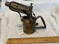 Overview photo of the vintage WW2 brass blow torch with measuring ruler for scale.