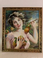 Full view of the framed oil on canvas painting showing a smiling woman holding oranges with detailed brushwork and colors.