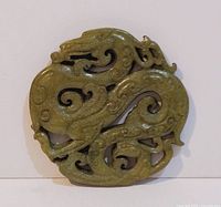 Overall view of the round green jade carving showing dragons in openwork.