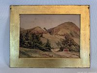 Full view of framed watercolor painting showing rural hillside landscape, cabin, trees and rolling hills