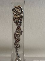 Close-up of sterling silver floral overlay on the glass vase showing detailed roses and leaves.