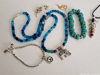 Full display of jewelry lot showing necklaces, bracelets, and charms