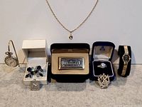 Full lot showing mixed jewelry pieces and watches arranged on a surface.