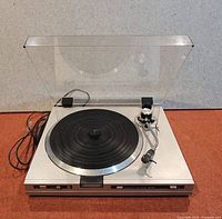 Front view of the Sansui turntable with dust cover open showing the platter and tonearm.