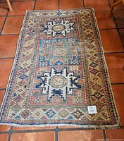 Full view of the Southwestern style area rug on tiled floor showing all edges and intricate geometric patterns.