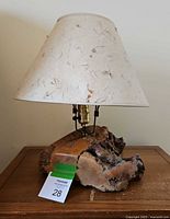 Front and slightly angled view of driftwood desk lamp with natural paper shade showing notable cracks on driftwood base.