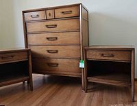 Full view of dresser between two nightstands on wood floor