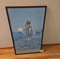 Full view of the framed print leaning against the wall, showing print and frame condition.