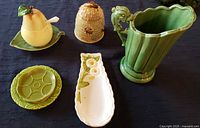 Overview of the vintage and mid-century ceramic kitchen items arranged on table with black cloth.