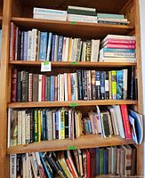 Full view of bookcase shelf with a variety of medical, philosophy, and healing books including an Encyclopedia of Natural Medicine and Integral Health Solutions.
