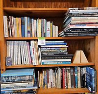 Bookshelves with a wide variety of nature, USA, California, and space-related books and a pair of agate bookends on one shelf