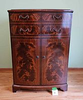 Front view of the vintage RCA Victor dark wood cabinet showing drawers, doors, wood grain, and handles.