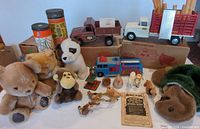 Wide view of full lot showing trucks, Tinker Toy tubes, grader box, plush and figurines