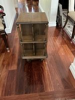 Front angle photo showing the four sides and carved vertical columns, with visible compartments inside.