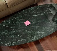 Top view showing elliptical green marble surface with white veins and pink lot label in center
