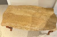 Top view of the coffee table showing the light brown marble surface and wooden legs.