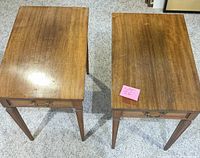 Top view of two solid wood end tables with drawers, showing wood grain and tapered legs