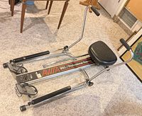 Side perspective of Avitta 950 rowing machine showing folding frame, padded seat and pedals