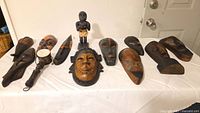 Group shot of all masks and figurine laid out on table