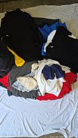 Pile of mixed blank T-shirts in assorted colors and sizes