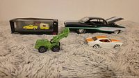 Group shot of all vehicles including boxed set, loader, two loose cars