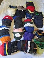 Multiple stacks of assorted hats laid out on sheet